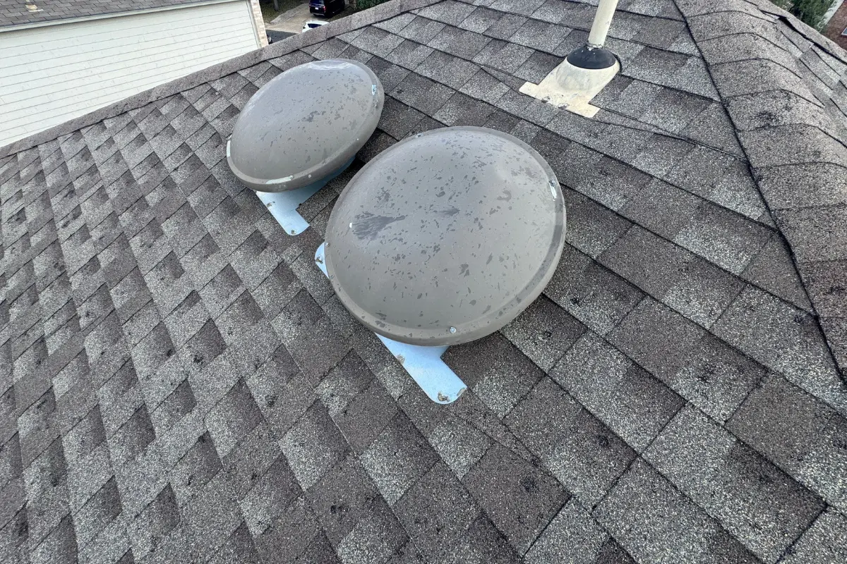 Hail impact splatter marks across two roof turbine vents at a home on Staghorn Mill in Converse