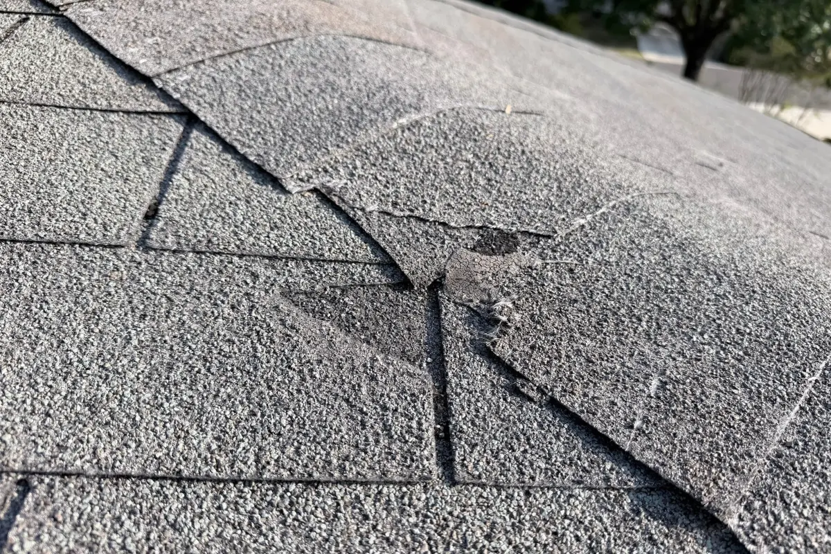 Broken 3-tab shingles with a failed seal found during roof inspection