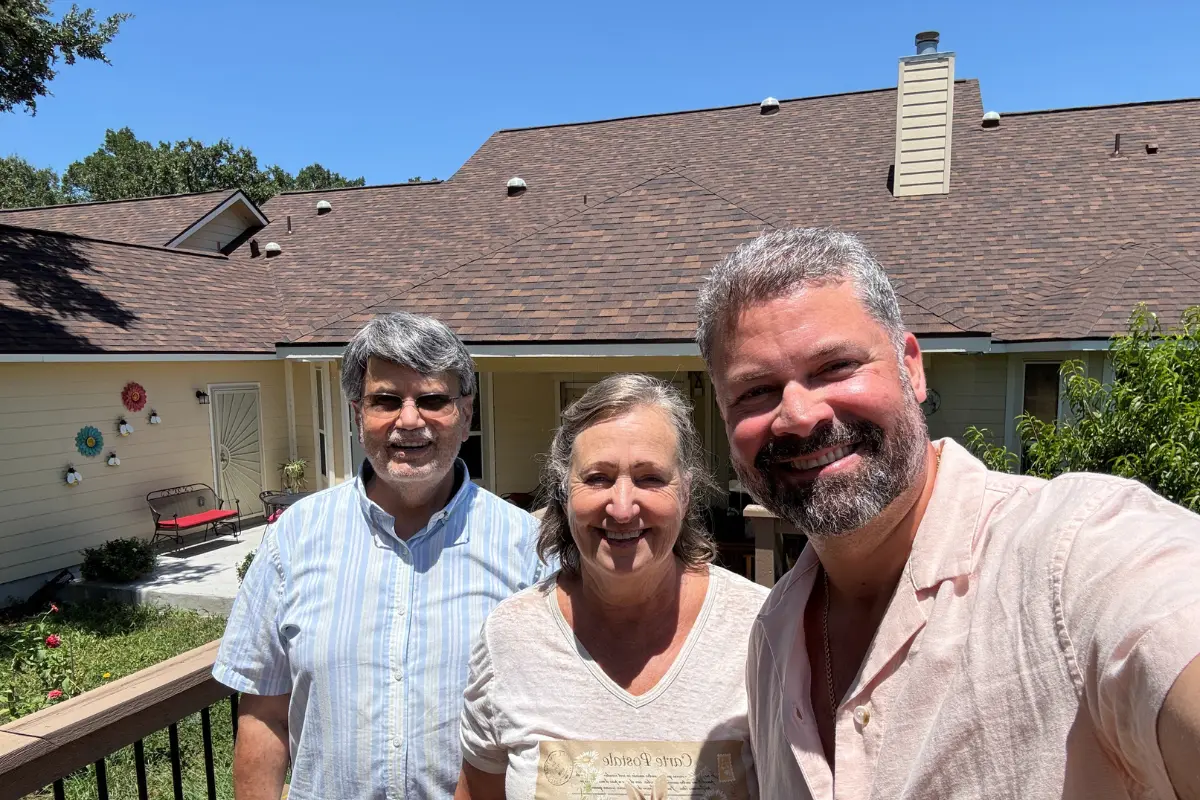 Jose Puente, civil engineer and owner of Atrium Roofing, reviewing a roof plan with homeowners in San Antonio