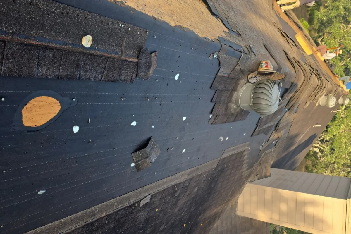 Multiple layers of old felt paper exposed during tear-off of a Bergheim, TX roof