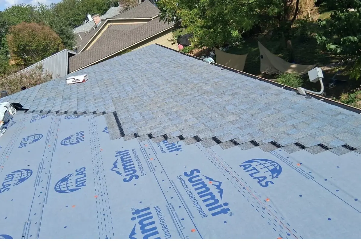 Roofer installing Atlas Pinnacle Sun shingles on a San Antonio roof